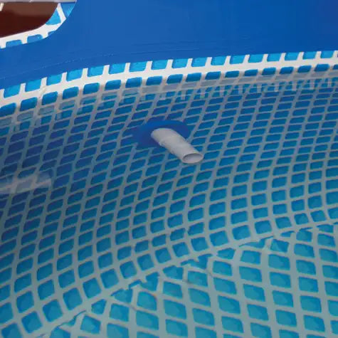 Close-up of a blue pool cover with a grid pattern and a white drain plug.